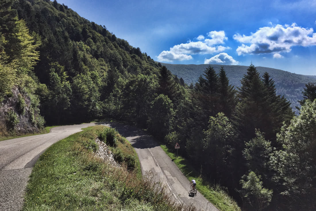 Cycliste sur route de montagne, descente en épingle dans les Vosges