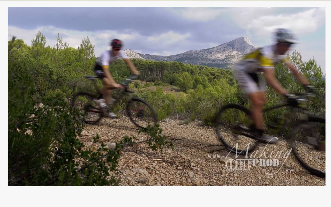 Deux vététistes sur un chemin caillouteux, massif de la Sainte-Victoire en arrière-plan